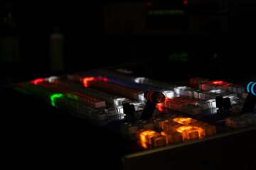 Closeup of lighted mixing console isolated on black background