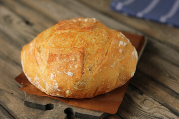 Fresh round pumpkin bread on the table close-up. Fresh bread on the kitchen table. Healthy food and traditional bakery concept. Rustic style.