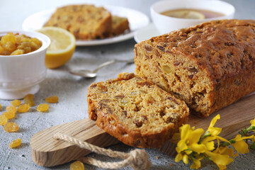 Traditional English tea raisins cake, egg-free cake and cup of lemon tea