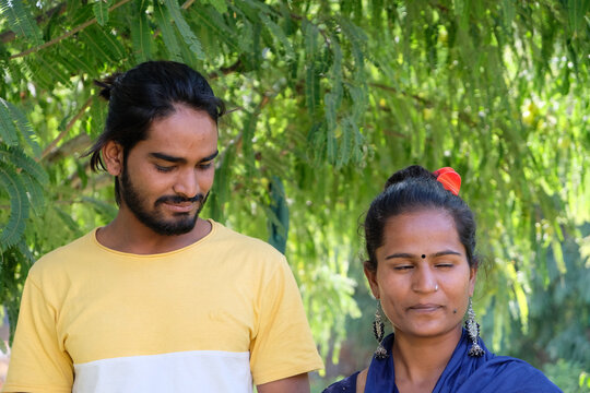 Shallow focus of an Indian male and female looking at something with smiling faces