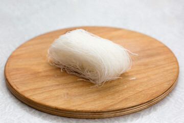 Pressed dry white vegetable noodles on a cutting board