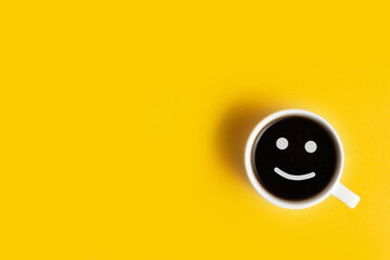 Top view of the white cup of coffee on the yellow background with a free space for text. Getting up...