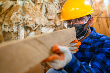 Asian male craftsmen craftsmen wood carving In workshop The background is a carved woodcarving room.