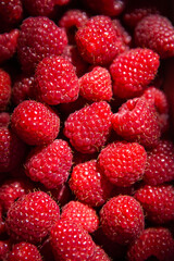 Fresh sweet juicy raspberries in a wooden basket close-up. View from above.
