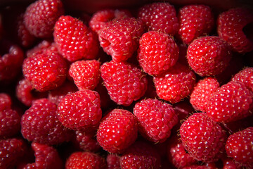 Fresh sweet juicy raspberries in a wooden basket close-up. View from above.