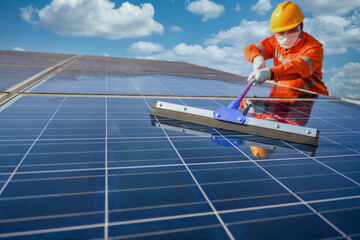 Asian male worker or engineer In a solar power station The solar panel is being cleaned using a mop...
