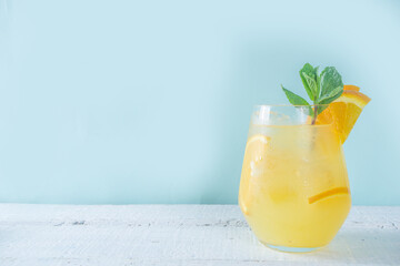 One glass with summer cold drink lemonade with lemon slices, ice and mint copy space