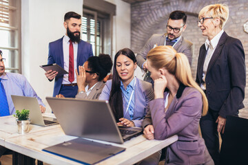 Creative diverse colleagues team discuss online project use computer at workplace