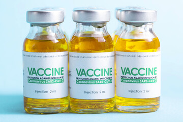 Row of bottles with coronavirus vaccine on a blue background. Side effect of the vaccine, macro, clinical