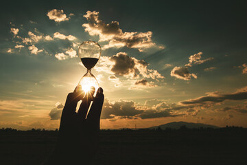 Life time passing concept. Hourglass at sunset time. concept time is money.