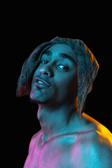 African-american young man's portrait on black studio background in neon. Concept of fashion, man's beauty, youth culture, performance.