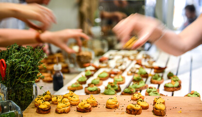 Hands grabbing snacks from table in blurred motion.