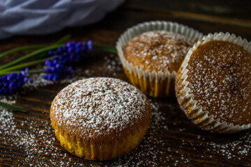 Cupcakes with orange on wooden background with blue flowers