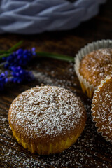 Cupcakes with orange on wooden background with blue flowers