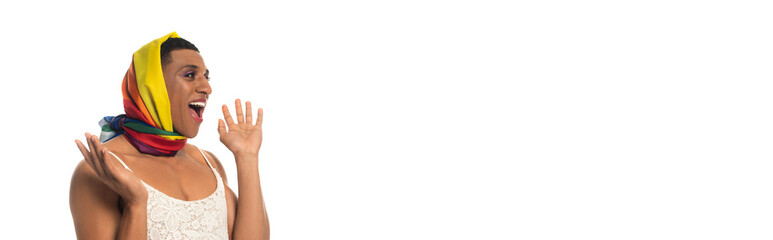 amazed african american transsexual man in dress and lgbt colors head kerchief isolated on white,...