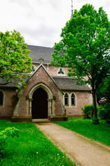 Fototapeta na wymiar Small Gothic Christian Catholic chapel in a green garden