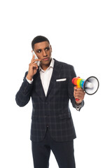 african american businessman talking on smartphone while holding lgbt colors megaphone isolated on...