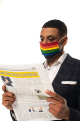 african american homosexual businessman in lgbt colors protective mask reading news isolated on...
