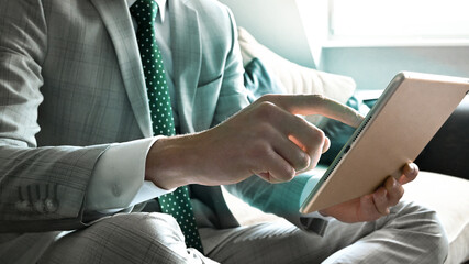Businessman in elegant suit working and typing on wireless pad at home office