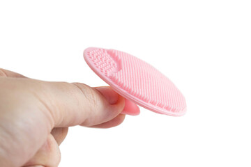 Pink cosmetic brush for cleaning the face in hand on a white background, isolate. Decorative