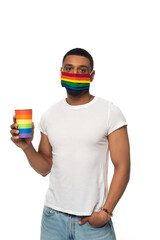 african american man with lgbt colors paper cup and protective mask standing with hand in pocket...