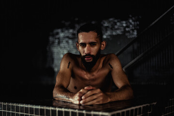 Fototapeta na wymiar Male model posing in a swimming pool