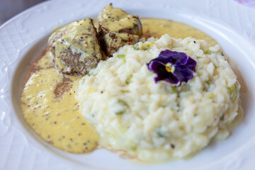 Delicioso risoto servido com filé mignon ao molho de madeira em prato branco.