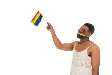african american transvestite man, wearing rainbow colors medical mask and holding lgbt flag...