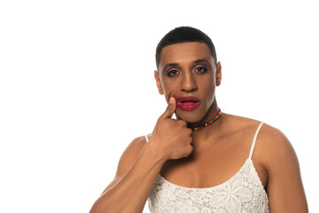 african american man in sundress looking at camera while smearing lipstick isolated on white