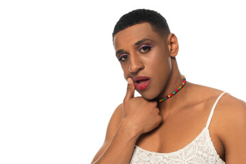 african american androgynous man smearing lipstick while looking at camera isolated on white