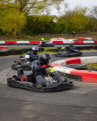 A panning shot of a racing kart as it circuits a track.