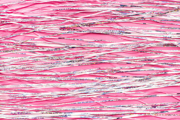 Pink shiny holographic tinsel background. Festive or party wallpaper close up