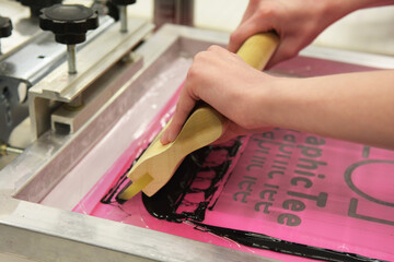 Screen printing, or silk screening, with black plastisol on t-shirts and posters.