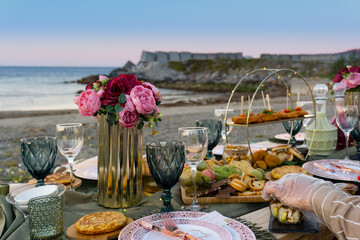 Mujeres preparando mesa para picnic nocturno en la playa
