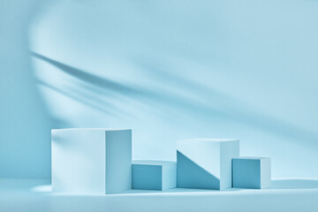 Blue background for product presentation with shadows and light. Empty podiums. Mockup.