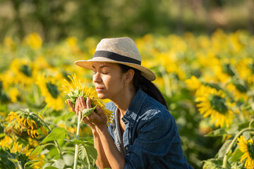 Beautiful young woman in a field of sunflowers in a white dress. travel on the weekend concept. portrait of authentic woman in straw hat . Outdoors on the sunflower field..