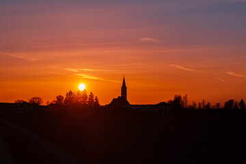 Fototapeta na wymiar Beautiful sunset with a church silhouette near Kirchdorf, Bavaria, Germany