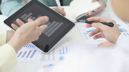 Asian business people meeting new startup project pointing graph discussion and analysis data charts and graphs.Business finances and accounting concept