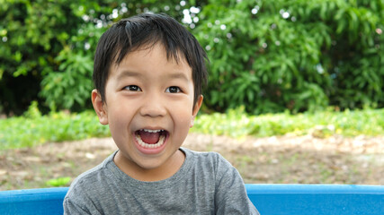 Asian cute child boy laughing with mouth open wide, whitening teeth. Happy kid with wow mouth,...