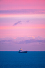 Fototapeta premium Ship in the Sea at Sunset