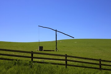 rural landscape with an old fountain on a green pasture