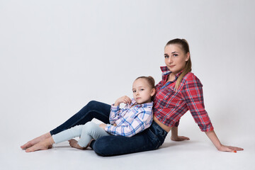 mom sitting on the floor leaning on her hand daughter comfortably on her lap