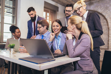 Creative diverse colleagues team discuss online project use computer at workplace
