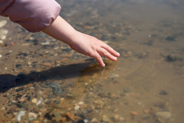 the child's hand reaches for the water. games with water