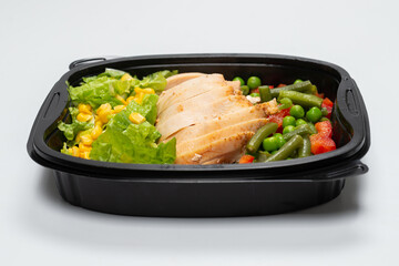 Ready food in a container. Stewed chicken, stewed vegetables.
