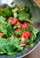 Fresh green organic salad in a metal bowl close up