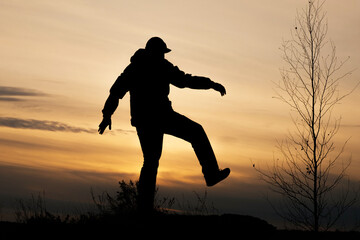 silhouette of a walking man on the background of sunset