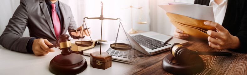 Business and lawyers discussing contract papers with brass scale on desk in office. Law, legal services, advice, justice and law concept picture with film grain effect