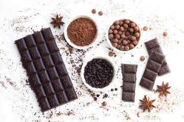 Chocolate bar and pieces with ingredients for cooking sweet food isolated top view
