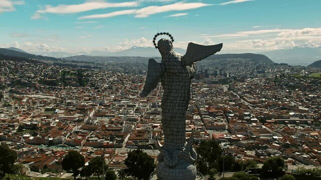 drone shot of downtown quito from behind "la virgen del panecillo" traveling in.